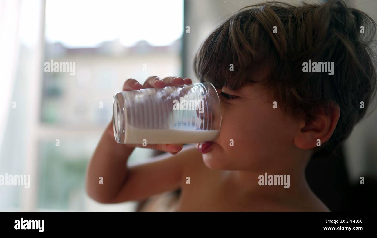 Small boy drinks milk. Closeup child face gulping high protein beverage