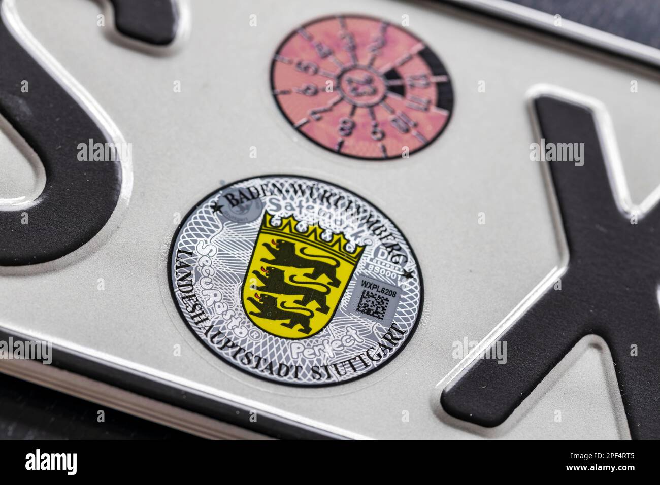 Official seal of the federal state of Baden-Wuerttemberg on a motor vehicle registration plate, TUeV badge and state coat of arms, Stuttgart Stock Photo