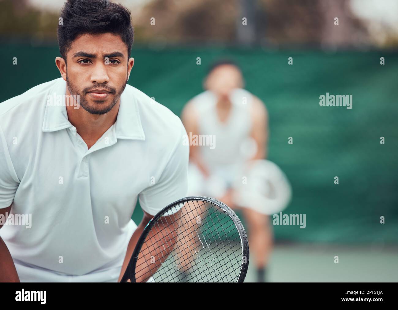 Two ethnic tennis players holding rackets and ready to play court game ...