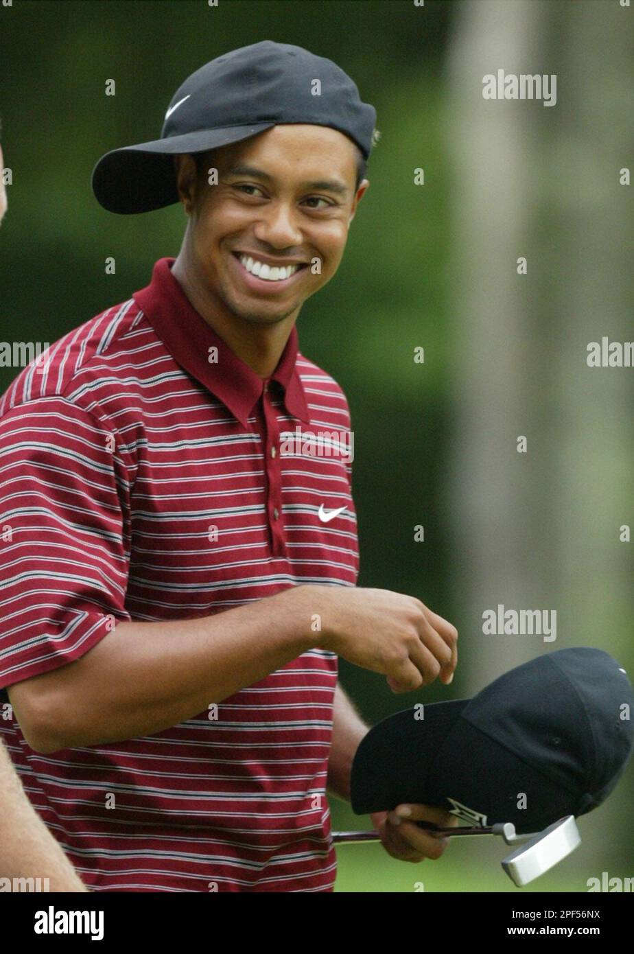 Tiger Woods smiles after turning his hat sideways Monday, Sept. 1, 2003,  after finishing play in the Deutsche Bank Championship in Norton, Mass.  Woods finished the tournament 11-under par. (AP Photo/Winslow Townson