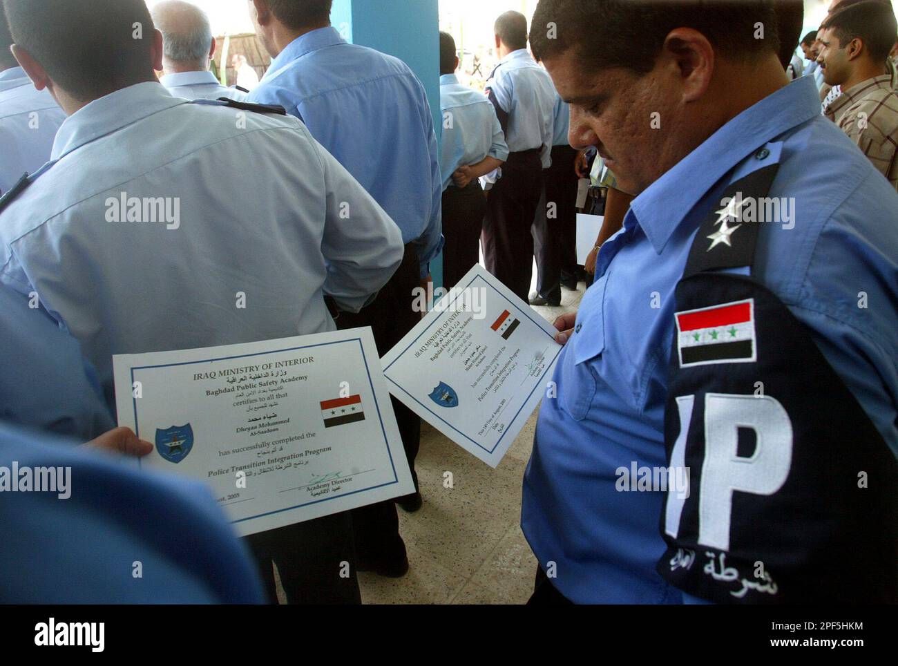 New Iraqi police officers look at their Police certificate after