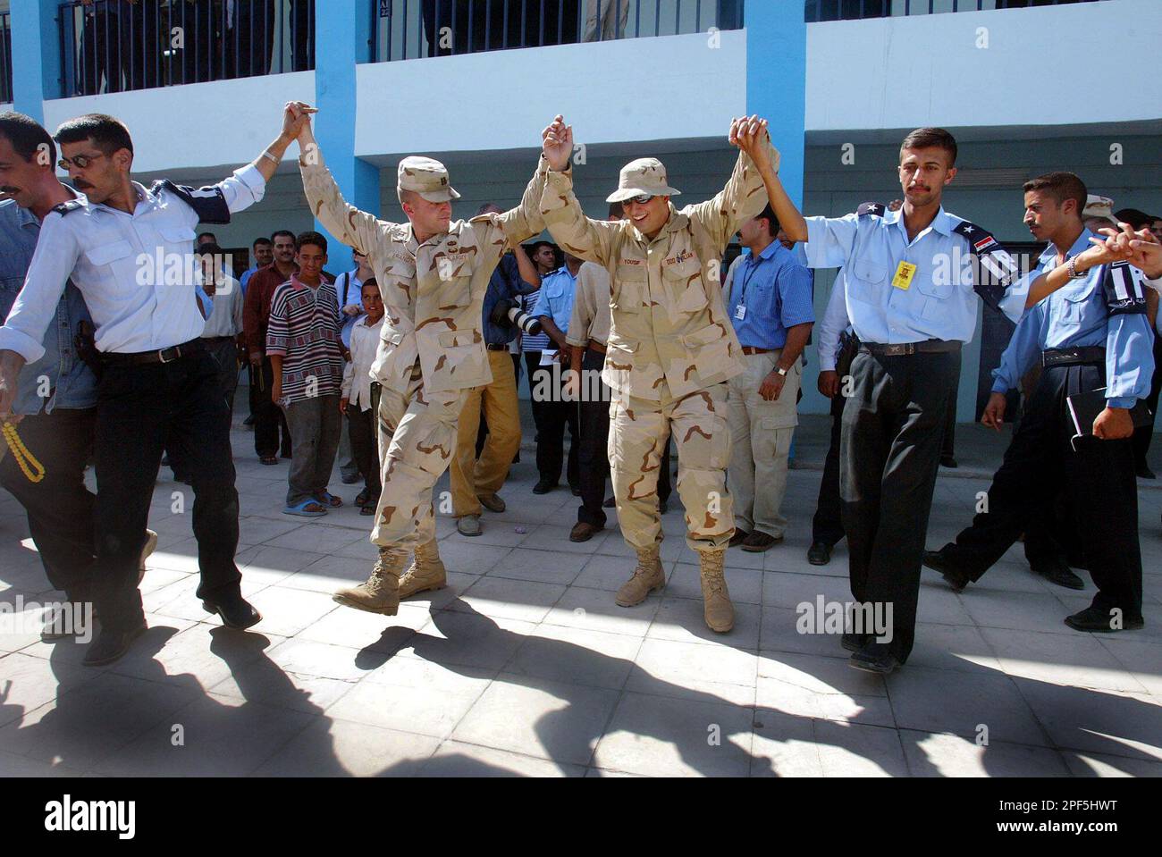 U.S. Army Military Police instructors, center, dance with Iraqi police