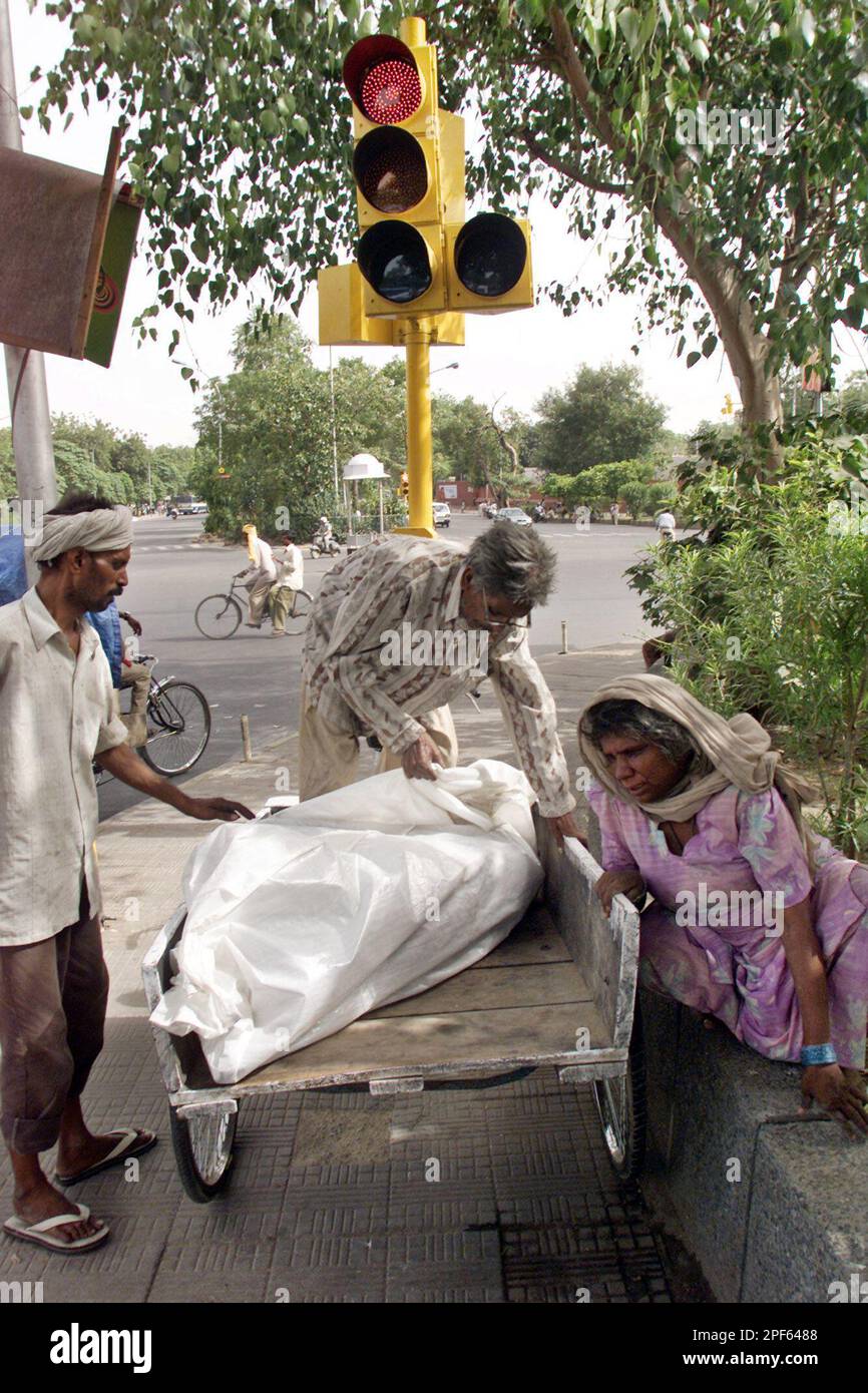 Mohammed Habib, 81, center, adjusts a body bag with a corpse as