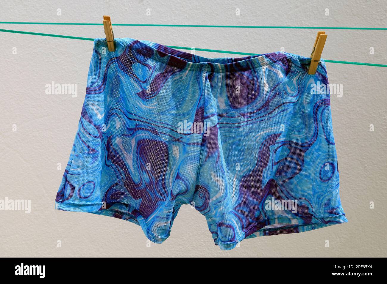 Swimming trunks on a washing line. Tan-through material. cym Stock Photo