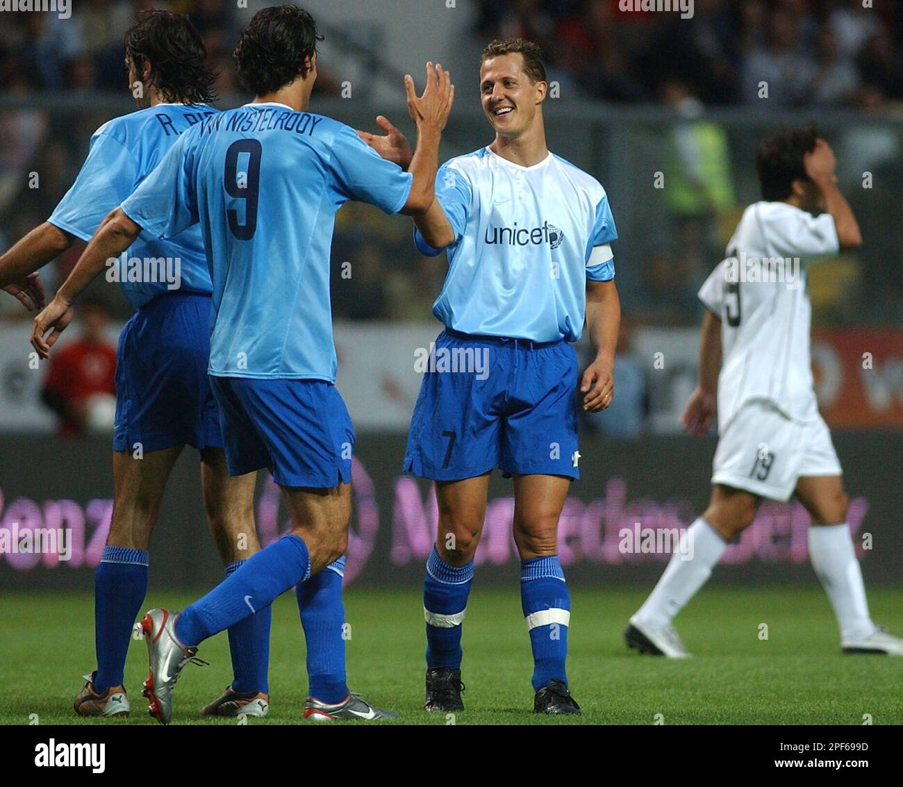 Formula One champion Michael Schumacher, center, celebrates with Dutch  striker Ruud Van Nistelrooy their UNICEF team first goal as FC Porto's Deco  playing for the Luis Figo Foundation team reacts, right, during