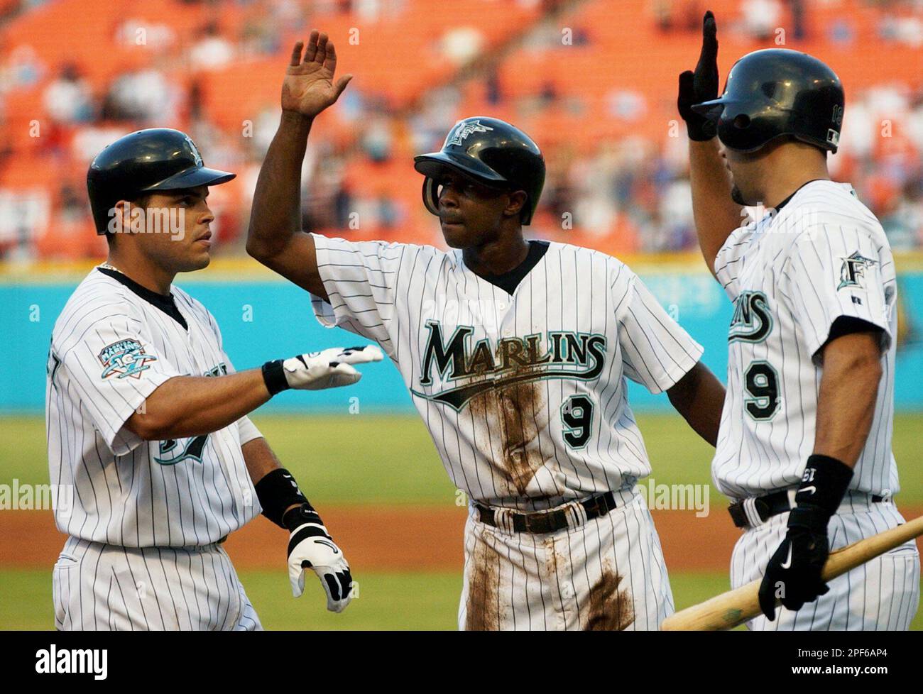 Florida Marlins' Ivan Rodriguez, left, is greeted by teammates Juan Pierre,  center, and Mike Lowell, right, after hitting a three-run home run against  Atlanta Braves pitcher Greg Maddux in the first inning