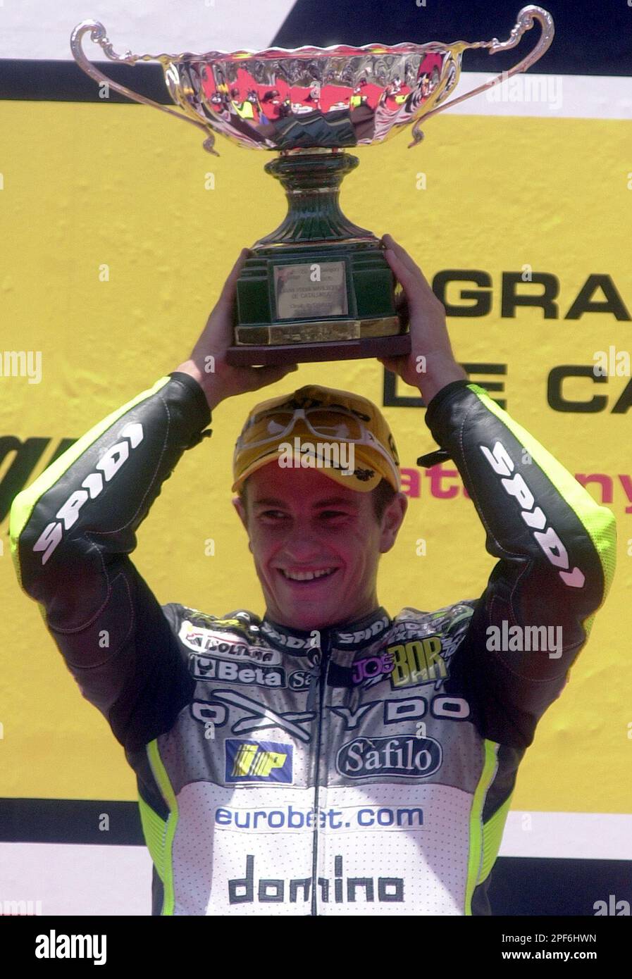 Randy De Puniet of France lifts the trophy after winning the 250cc race ...