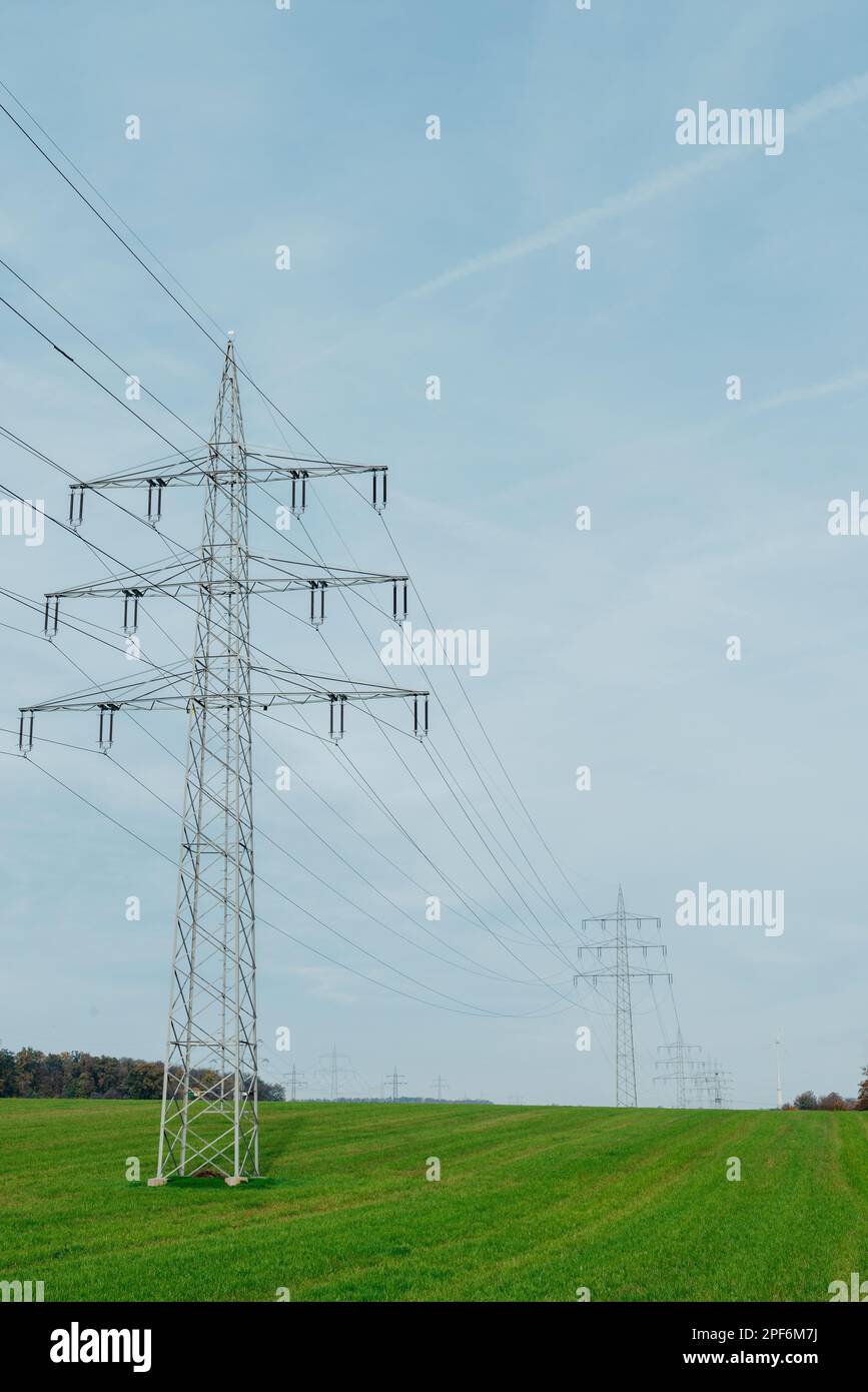 Power Through Line High voltage power lines leading through a green field. Transmission of ...