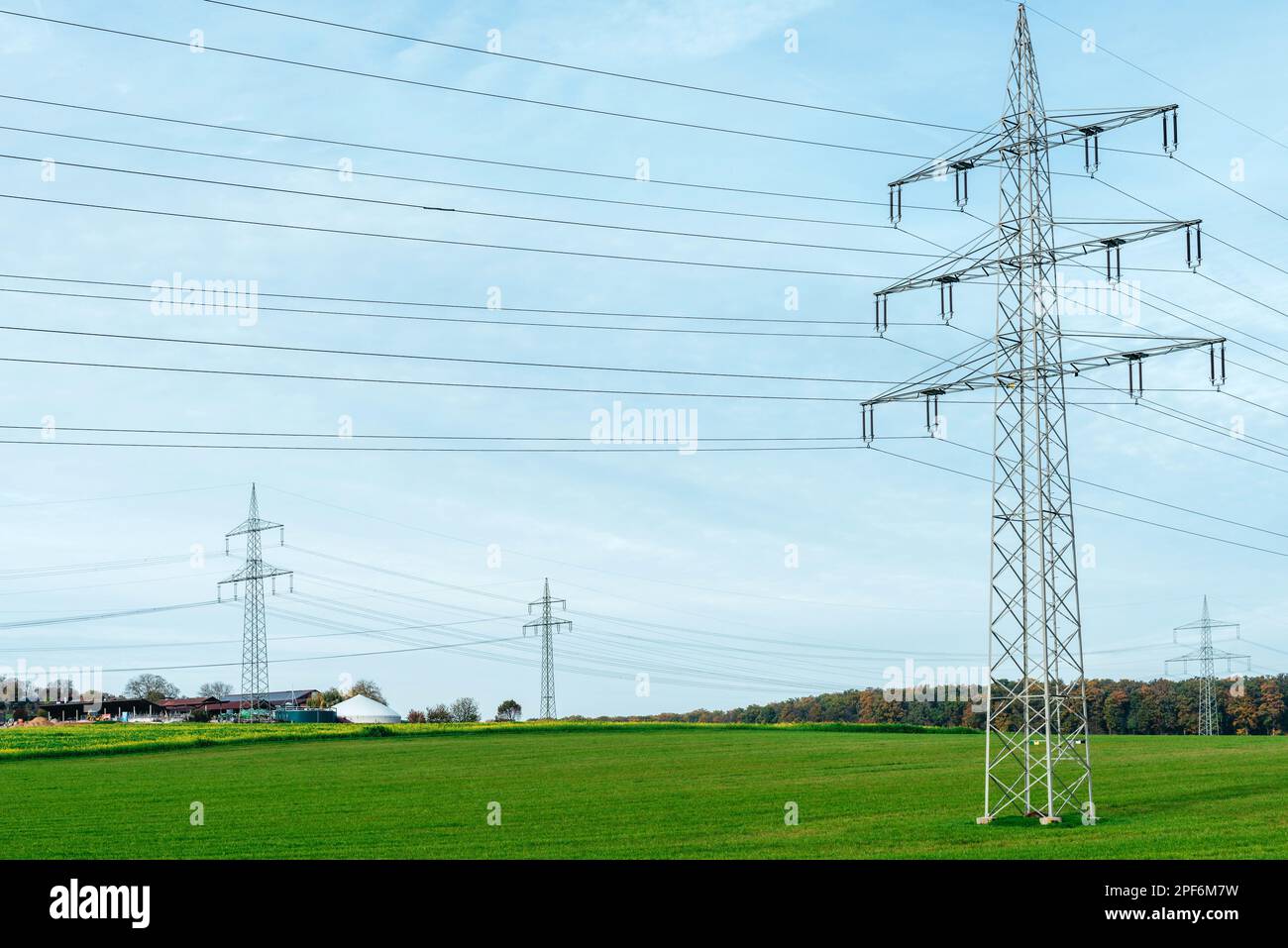 Power Through Line High voltage power lines leading through a green field. Transmission of ...