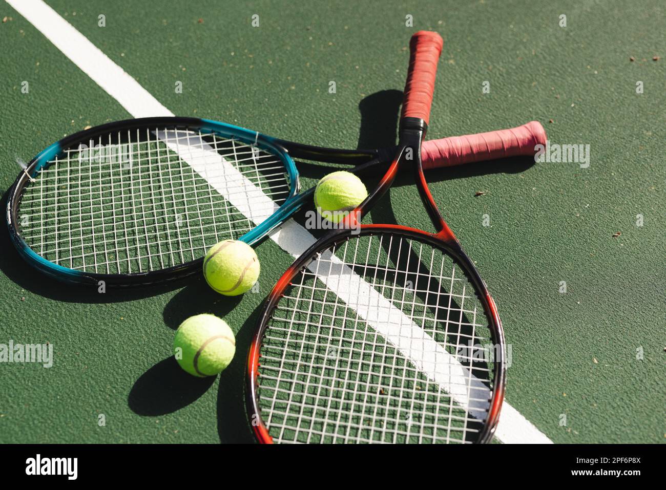 Close up of tennis rackets and tennis balls lying on tennis court