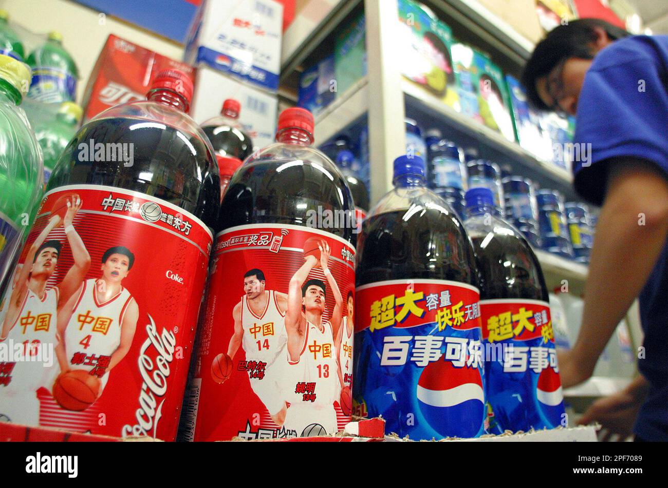A clerk standing near Coca-Cola bottles featuring Houston Rockets ...