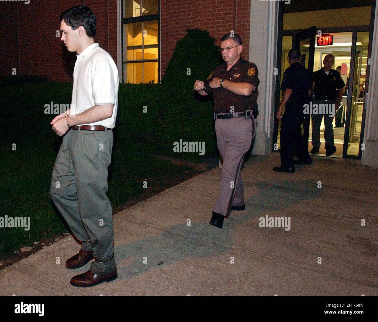 Zacheriah Tripp, 17, left, of Gower, Mo., is escorted out of the