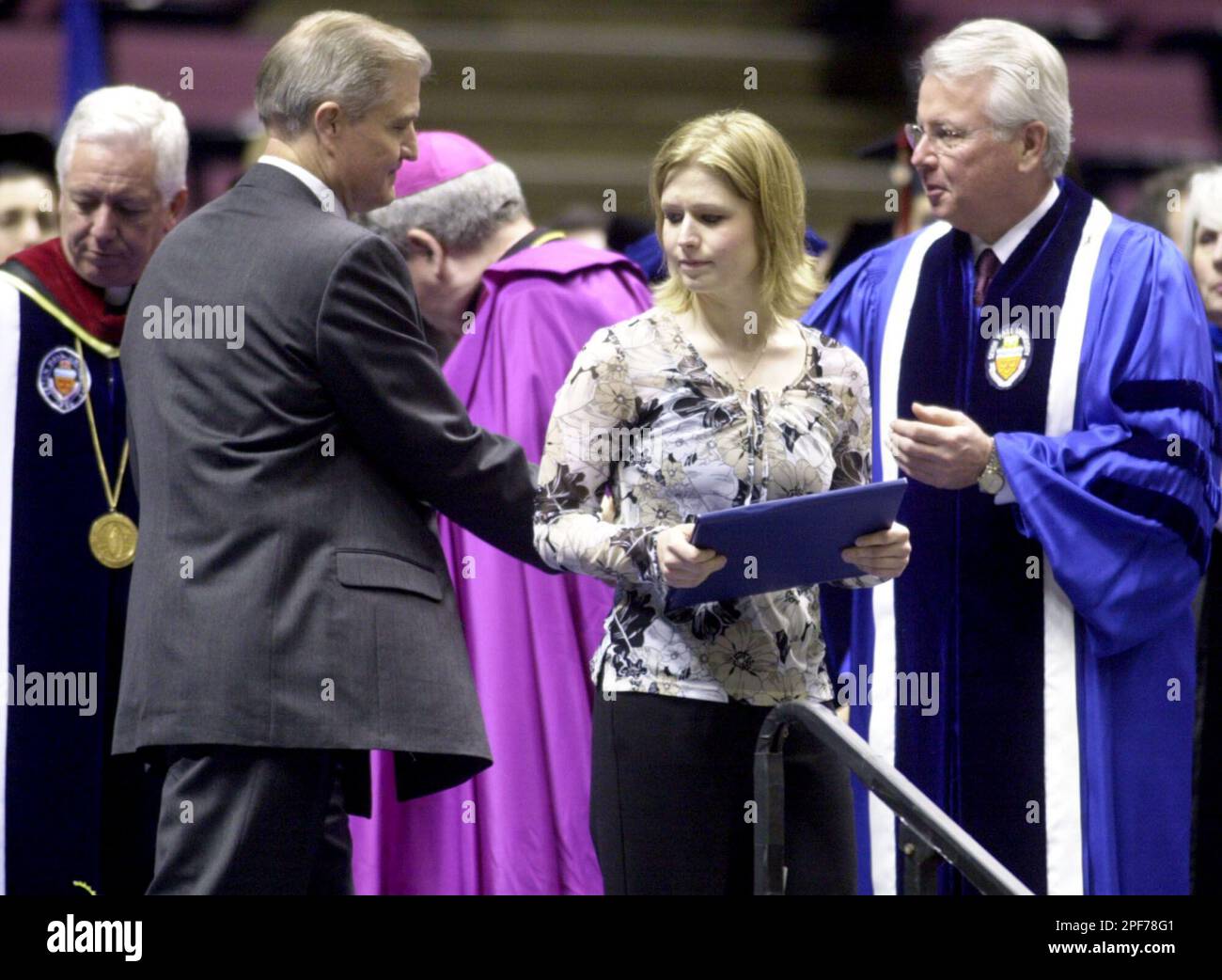 Melissa Karol, center, sister of Aaron Karol, who was killed in the Seton  Hall University dormitory fire in January 2000, holds her brother's  memorial degree as her father, Joseph Karol, second from