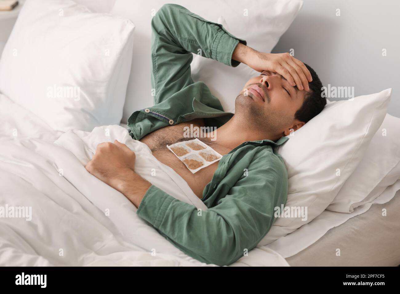 Ill young man with mustard plaster on his chest lying in bedroom Stock  Photo - Alamy