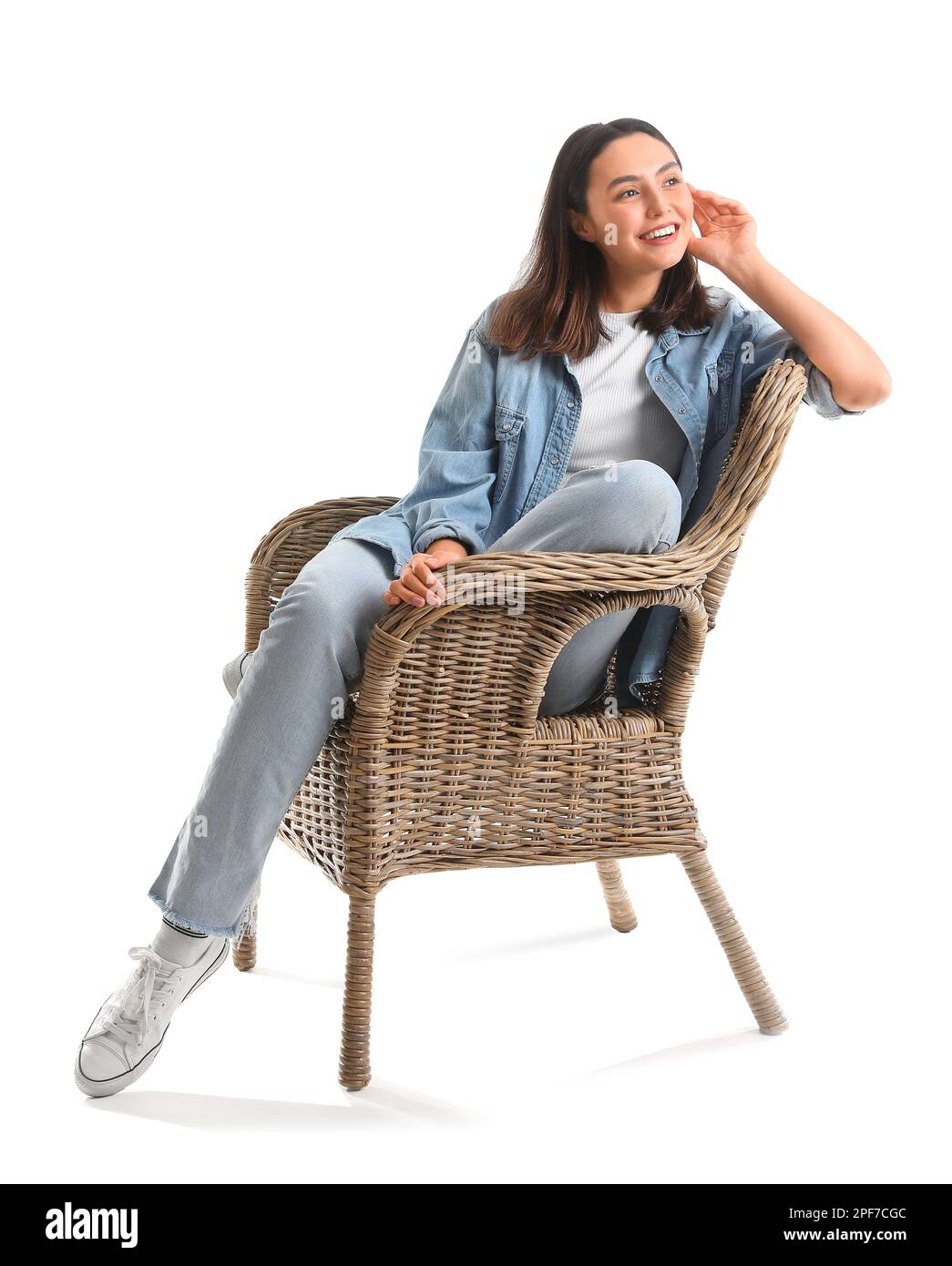 Young woman sitting in wicker armchair on white background Stock Photo ...