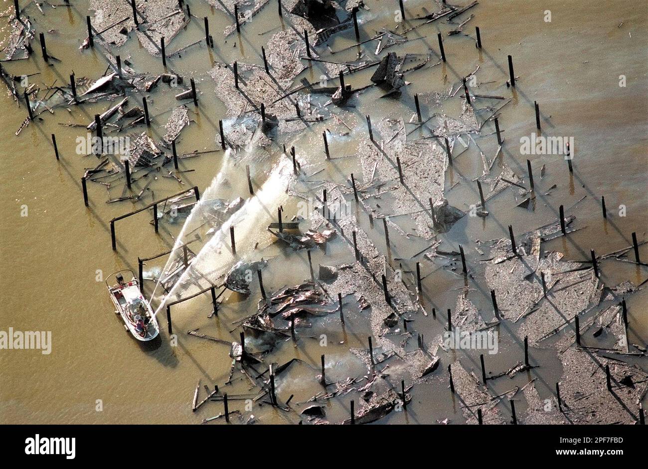 A fire boat crew aims water at fire hot spots on what was left of the