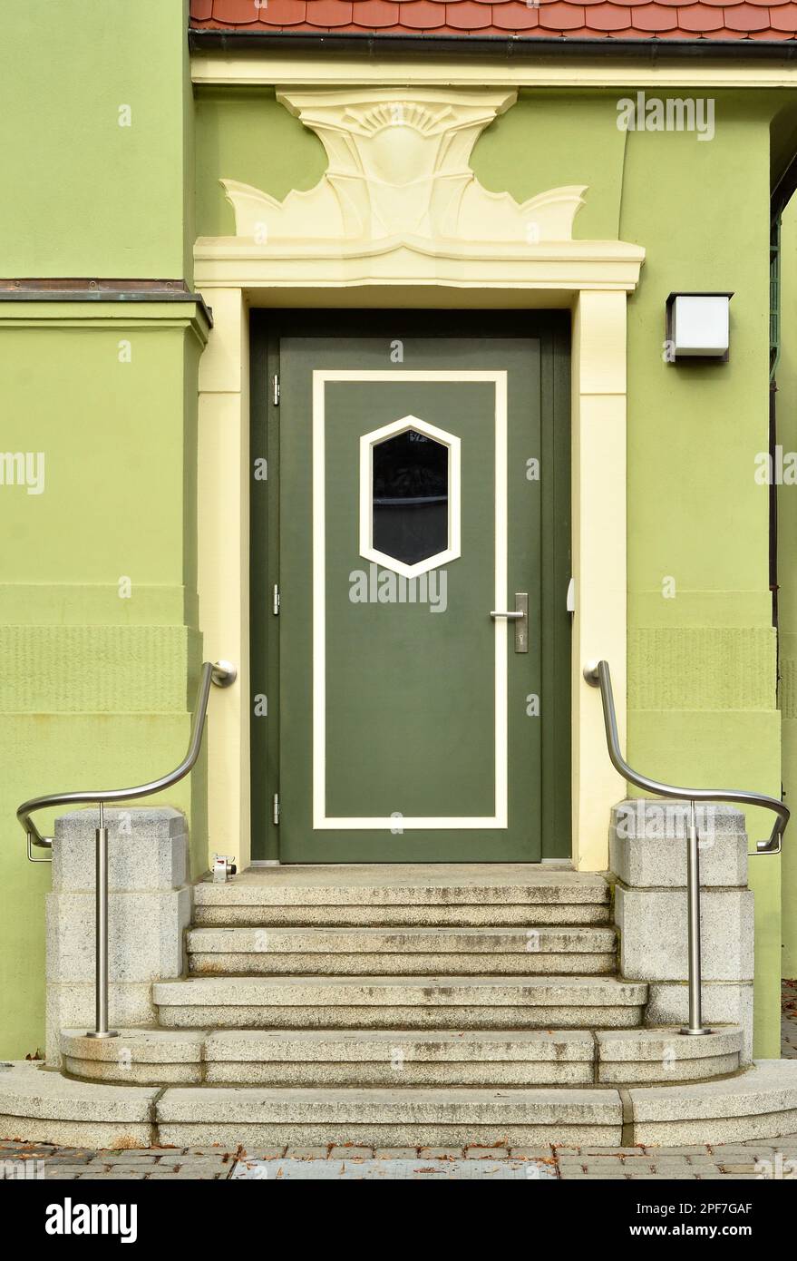 View of green building with wooden door and steps Stock Photo - Alamy
