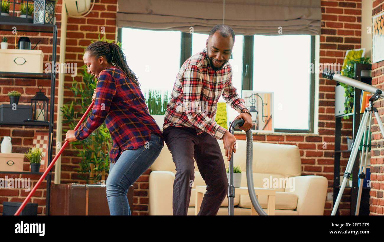 Active people dancing and doing housework together, having fun with