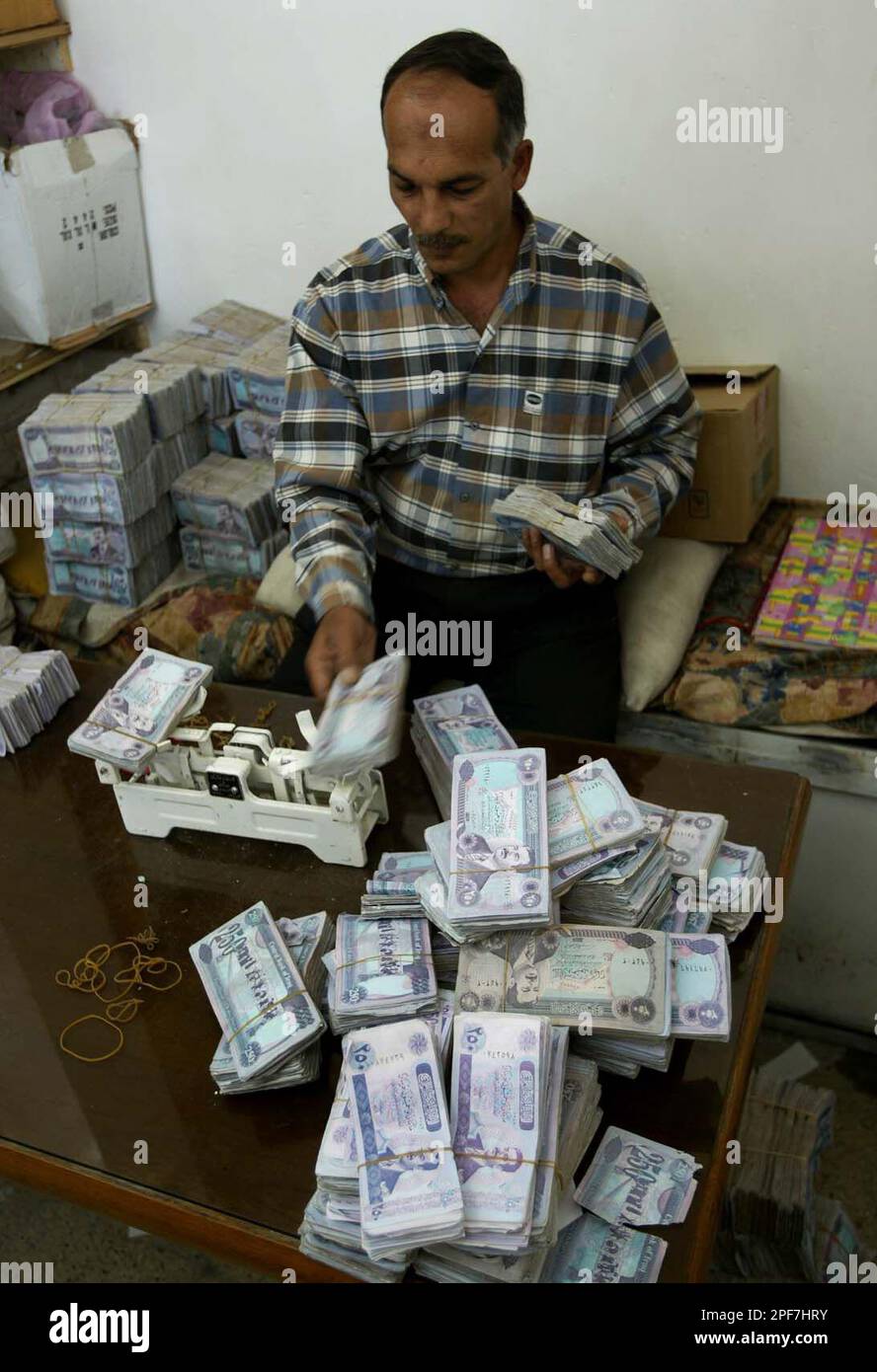 Iraq Money Stack A money changer uses a scale to count stacks of Iraqi Dinar in Baghdad ...
