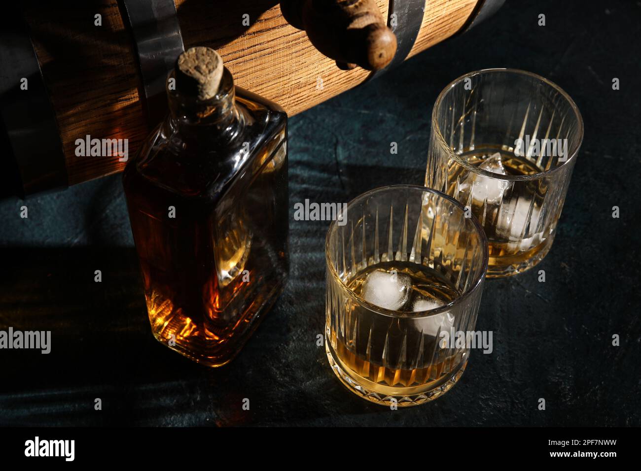 Glasses and bottle of cold whiskey on dark background Stock Photo