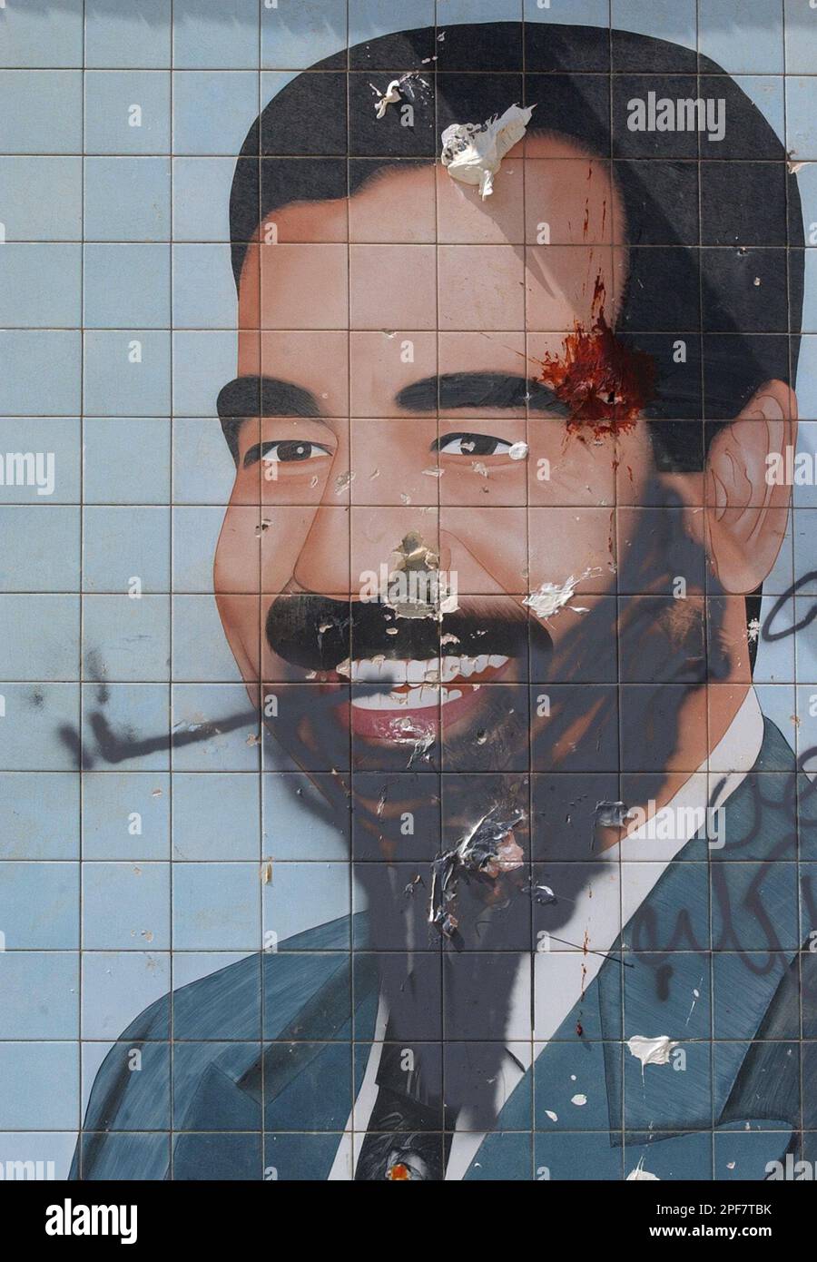 Vandalized mural of Saddam Hussein is seen in a street in Baghdad, Thursday April 17, 2003. U.S