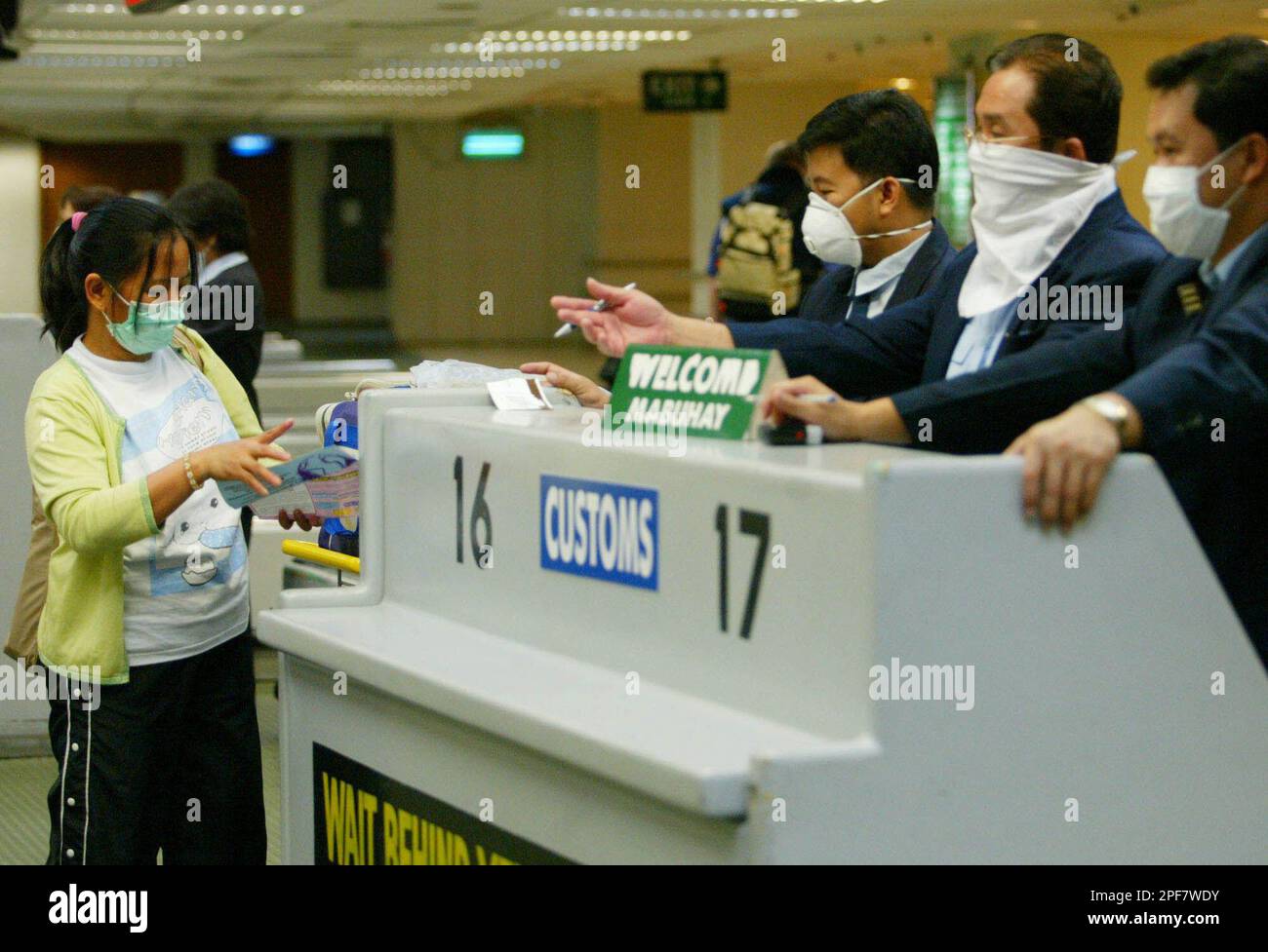 Customs personnel, wearing surgical masks to avoid catching severe