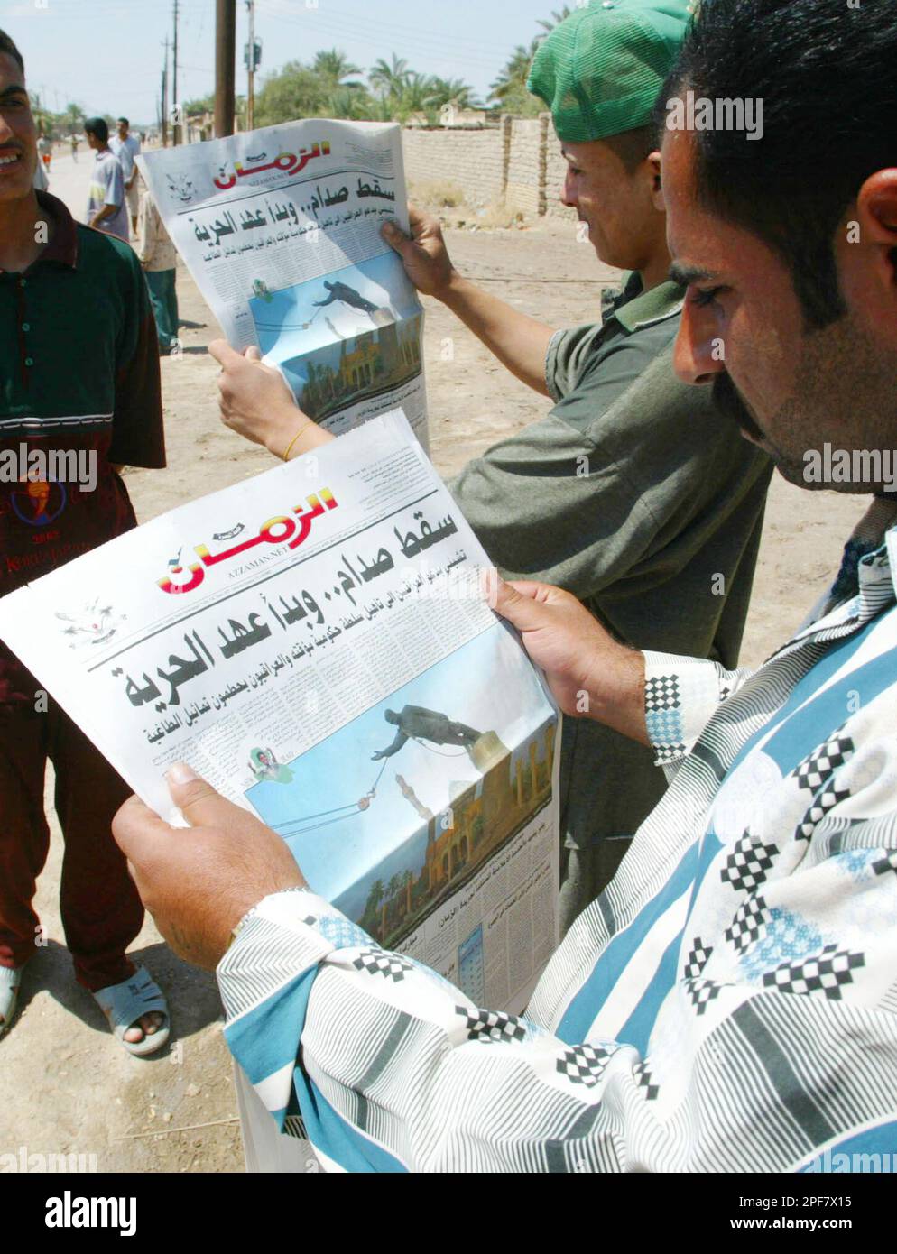 Iraqis read newspapers distributed by U.S.Marine PysOps officers