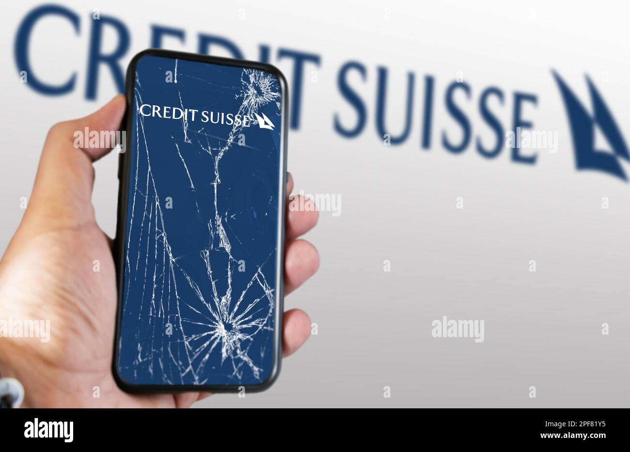 New York, US, March 2023: Hand holding a phone with the Credit Suisse logo on the cracked screen. In March 2023, Credit Suisse experienced a sharp dro Stock Photo
