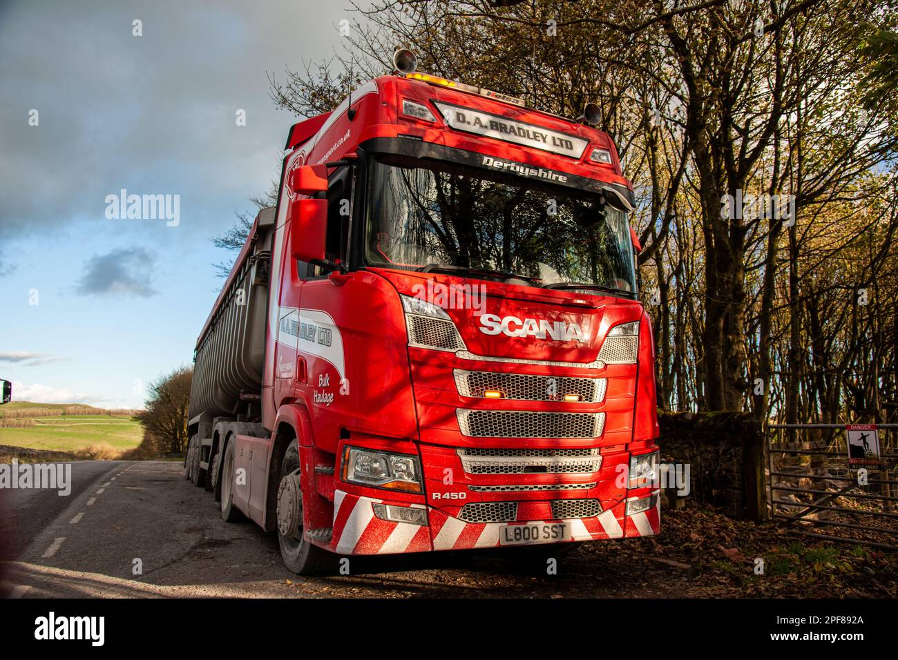 Scania truck pullling a bulk tipper trailer parked in a layby having climbed the hill from Tunstead Quarry in Derbyshire Stock Photo