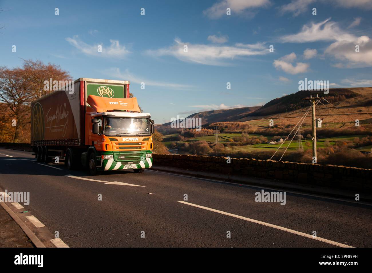 Scania truck pulling a curtainsider trailer driving along the A628 Woodhead Pass in Yorkshire on a sunny Winter afternoon Stock Photo