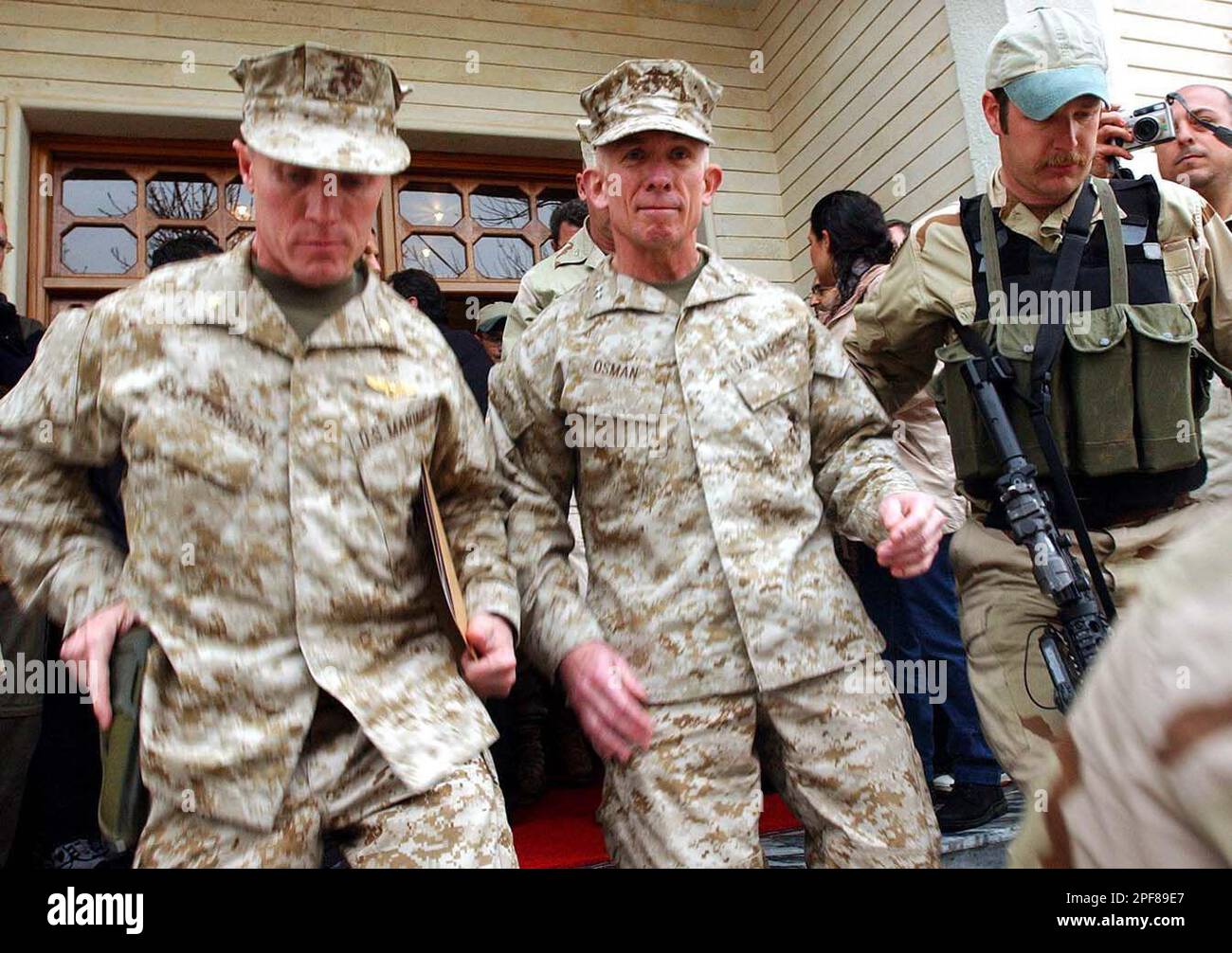 U.S. Marine Corps Maj. Gen. Henry P. Osman, center, is escorted by his unidentified bodyguards after news conference in Salahuddin, Iraq which is controlled by Kurdistan Democratic Party KDP, Monday, March. 24, 2003. Osman, said U.S. forces have arrived in northern in Iraq and he will oversee coordination of humanitarian and military operations in the Kurdistan region of Iraq. (AP Photo/Hasan Sarbakhshian) Stock Photo