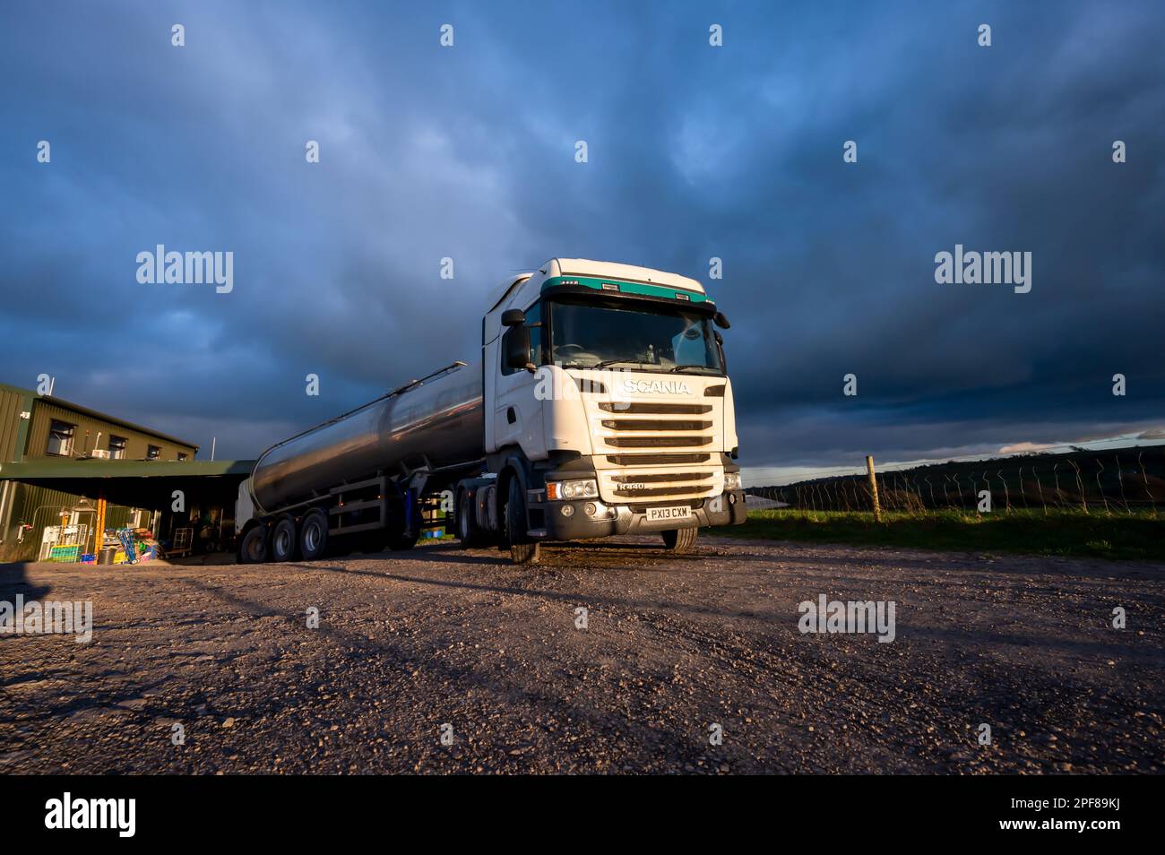 Scania truck pulling a tanker trailer loads up with milk from a dairy farm in South Yorkshire on a cloudy day in Winter Stock Photo