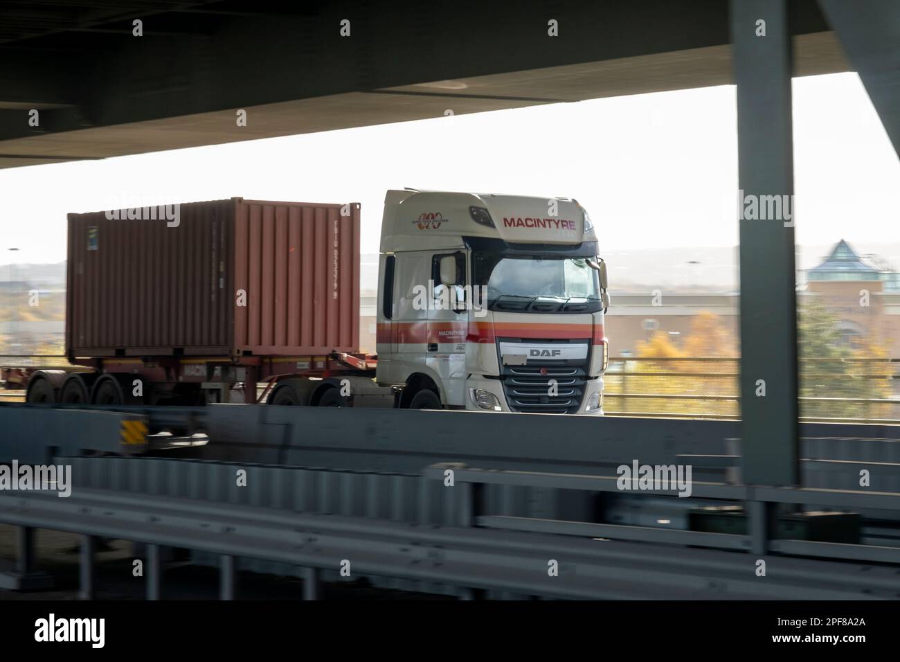 DAF container truck crosses the lower deck of Tinsley Viaduct, Sheffield, with Meadowhall in the background Stock Photo