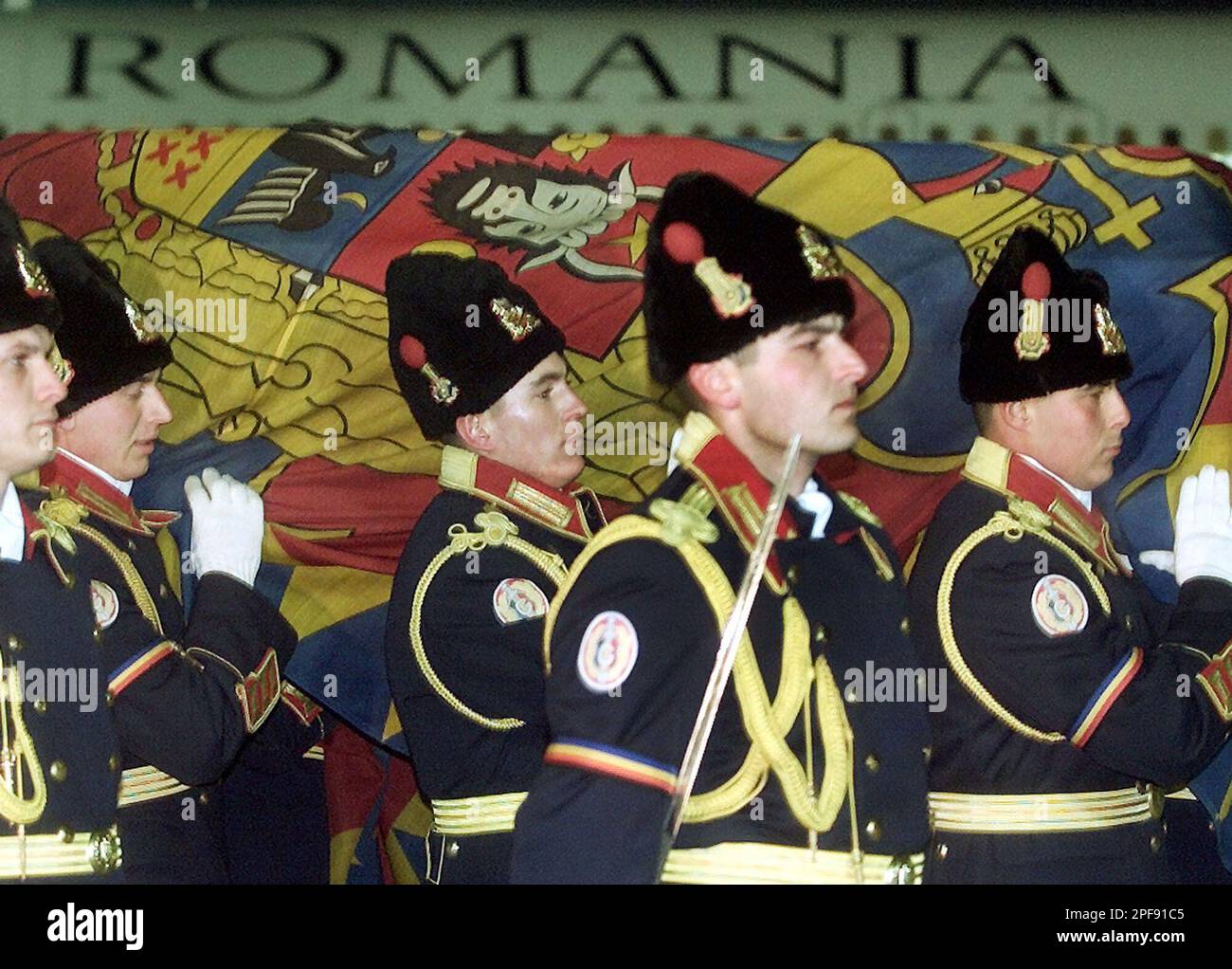 The flag-draped coffin of Romania's King Carol II is carried by ...