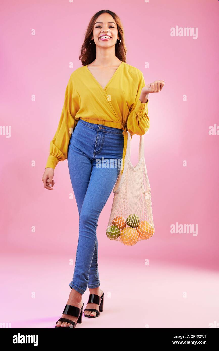 Shopping, portrait and woman nutritionist with fruit in studio for health, diet and healthy living on pink background. Face, groceries and happy girl Stock Photo