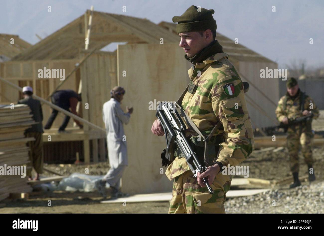 Italian Alpine Rangers guard Afghan men as they work on their new camp ...