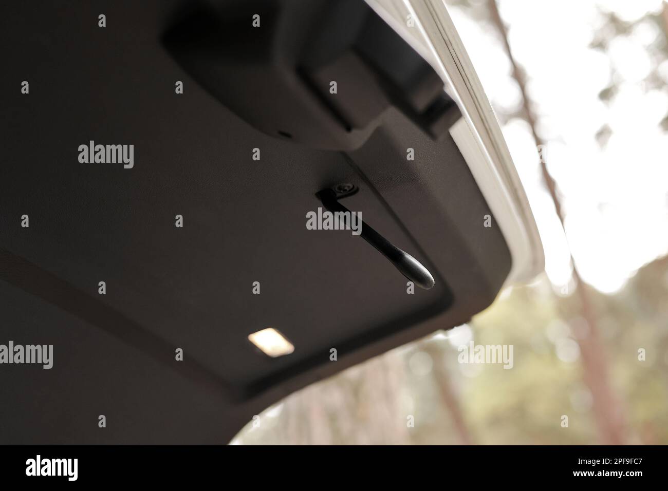 Trunk door handle. Modern white car trunk door opened. Vehicle outdoors