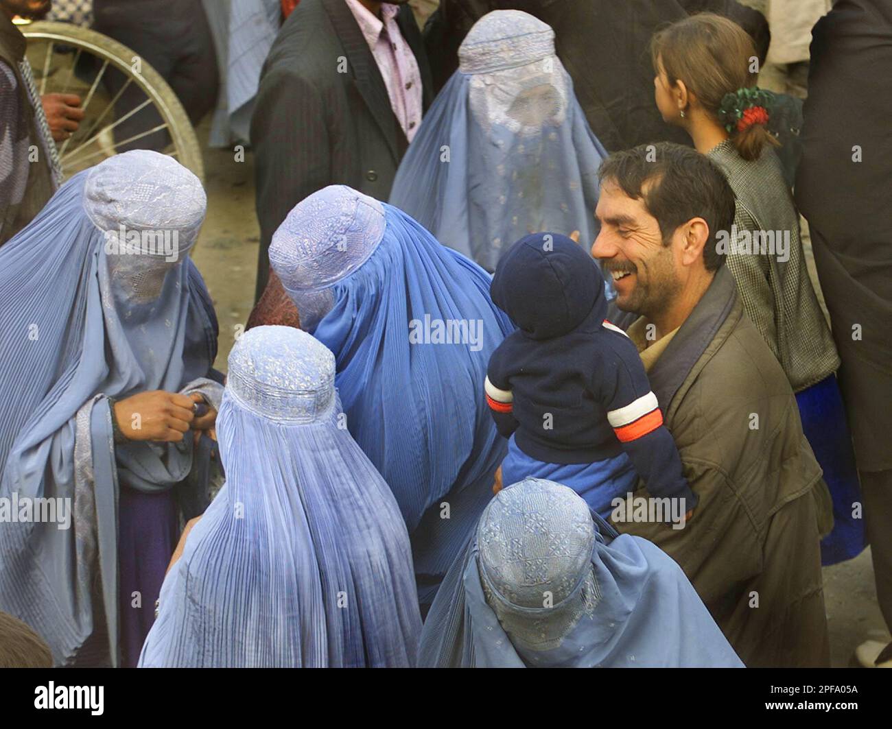 Afghan women look at the shade of a lipstick, left three, while their