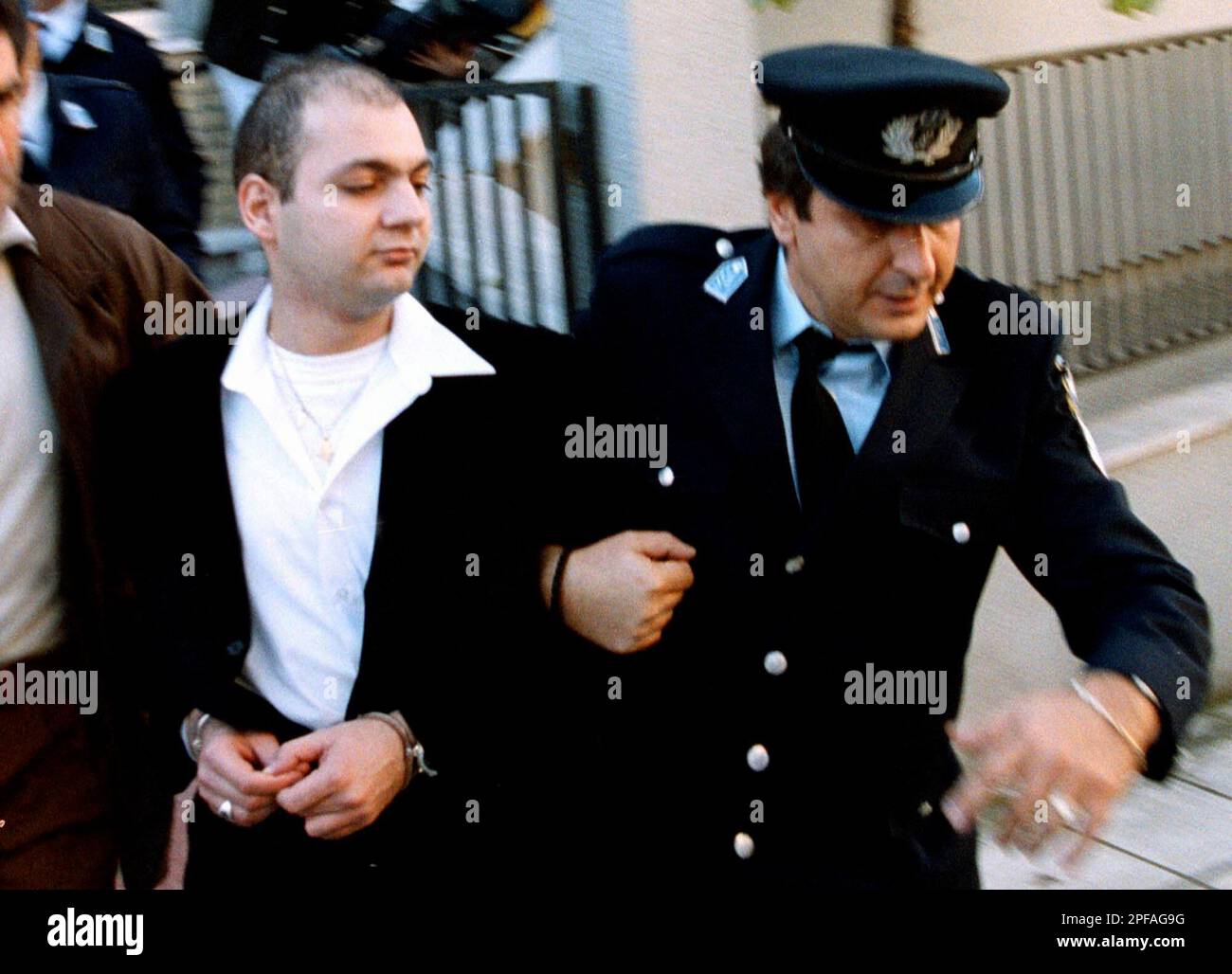 George Skiadopoulos is escorted by a policeman after a court appearance ...