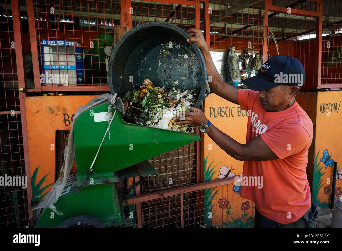 A worker pours garbage on a machine at a recycling facility in Malabon, Philippines on Monday