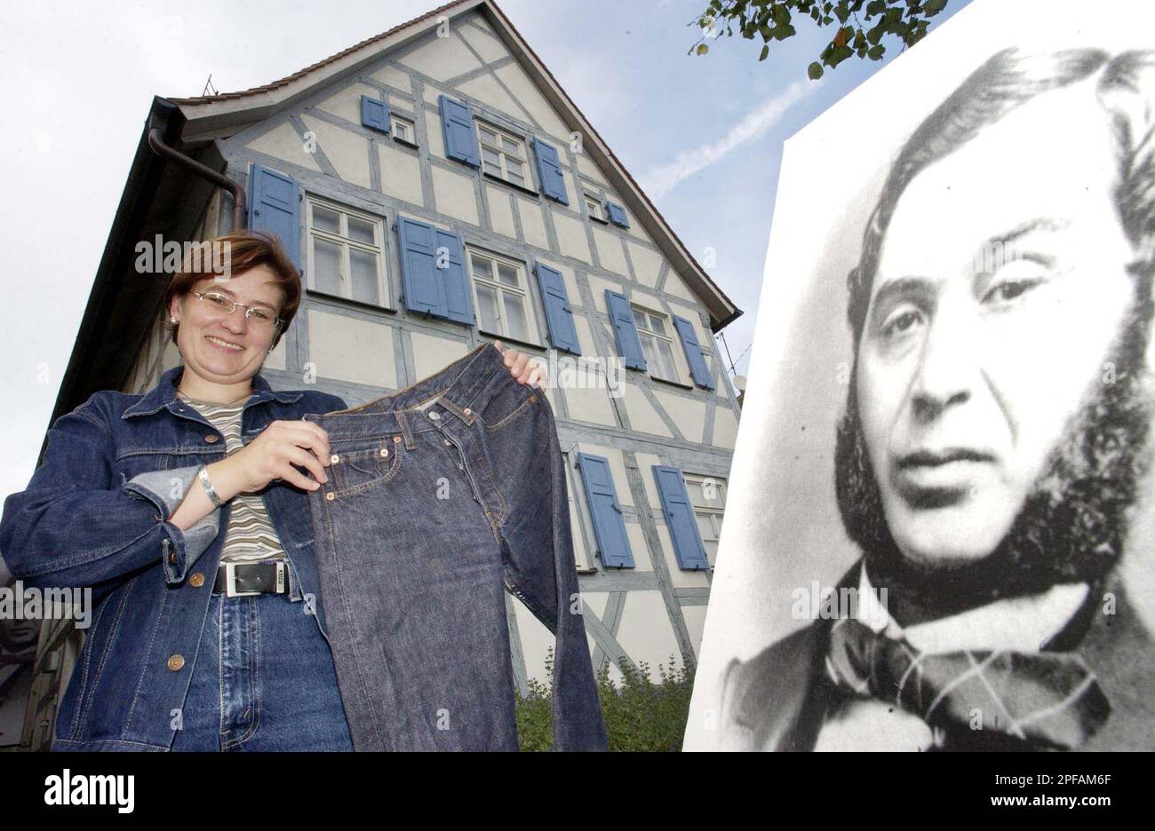 Tanja Roppelt, manager of the Levi Strauss Museum presents a pair of jeans  and a picture of inventor of the jeans, Levi Strauss, who was born in the  house in Buttenheim, nearby