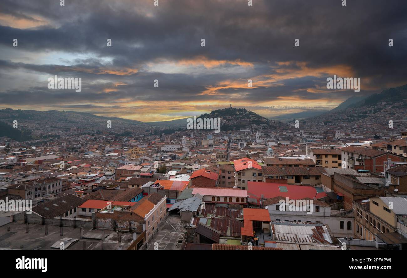 Panoramic view of the historic center of Quito with the Panecillo hill in the background during a cloudy sunset Stock Photo