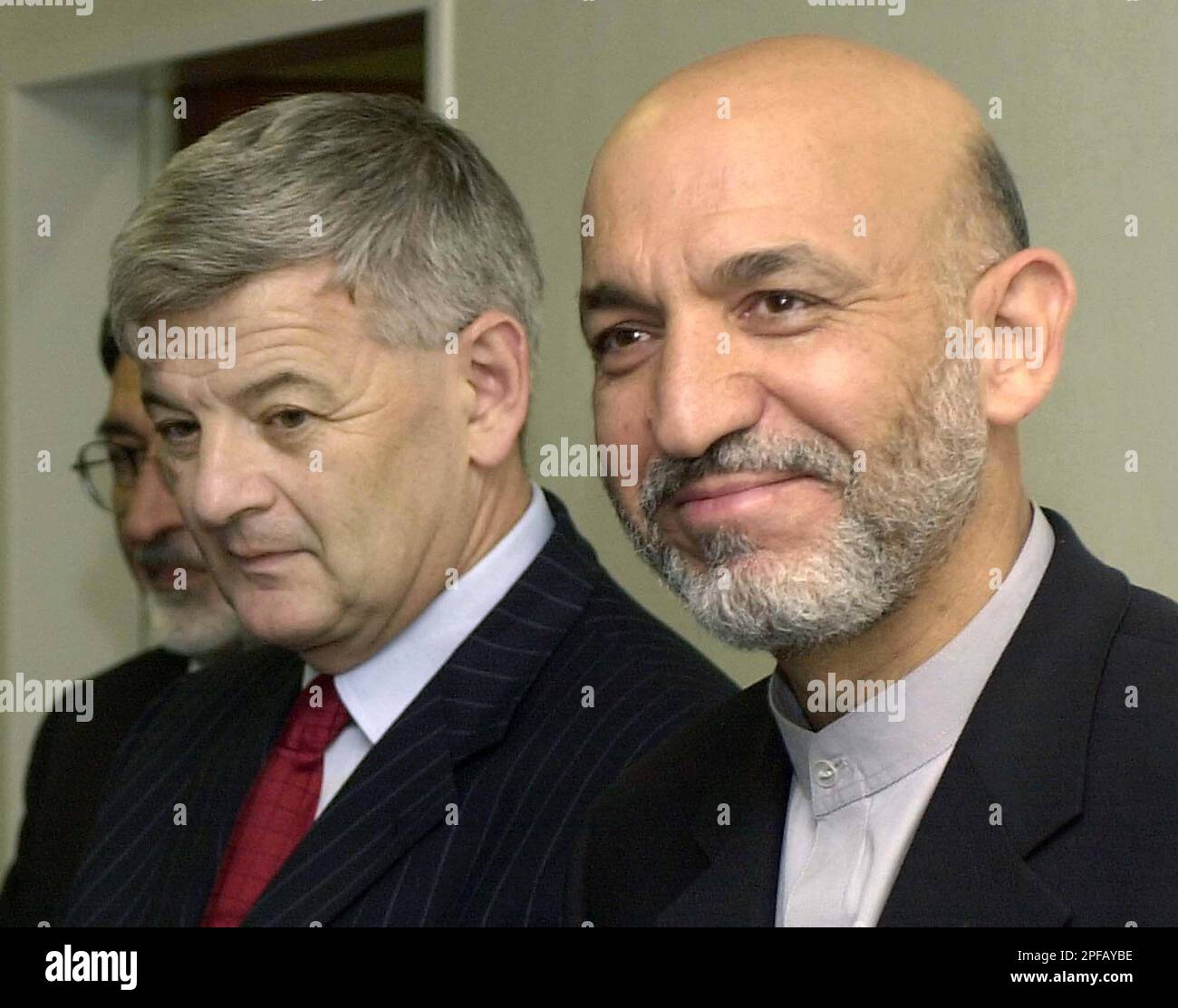 Afghan President Hamid Karzai, right, smiles after he was welcomed by German Foreign Minister Joschka Fischer, left, after he arrived at the U.S. Rhein Main Air Base, at the southern end of Frankfurt international airport, Germany, Sunday, Sept. 8, 2002. In his first trip since an attempt on his life three days ago, Karzai stopped over in Germany on his way to the United States where he will attend the U.N. General Assembly debate and ceremonies marking the anniversary of the Sept. 11 terrorist attacks. (AP Photo/Pool/Oliver Berg) Stock Photo