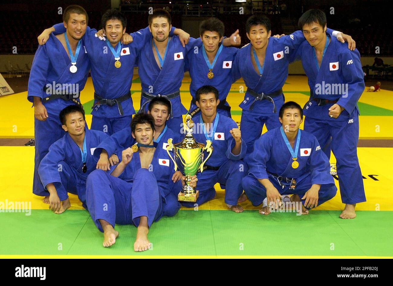 The Japanese judo team poses with their gold medals after winning the