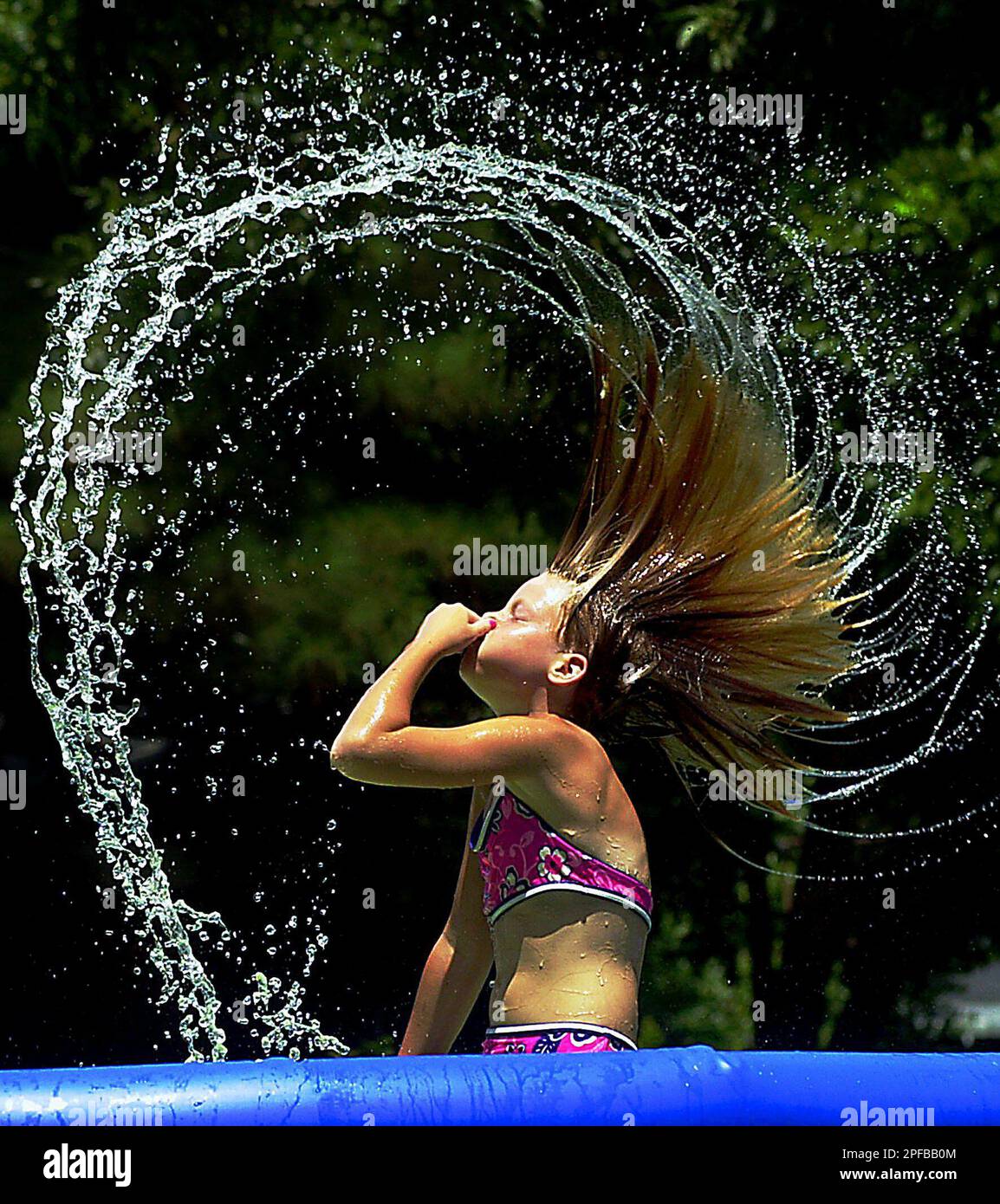 Paige Whittington bursts out of the cool water of a friends swimming pool  in Vidalia, La. on Friday, July 12, 2002 as temperatures reached into the  90s throughout the region. (AP Photo/The