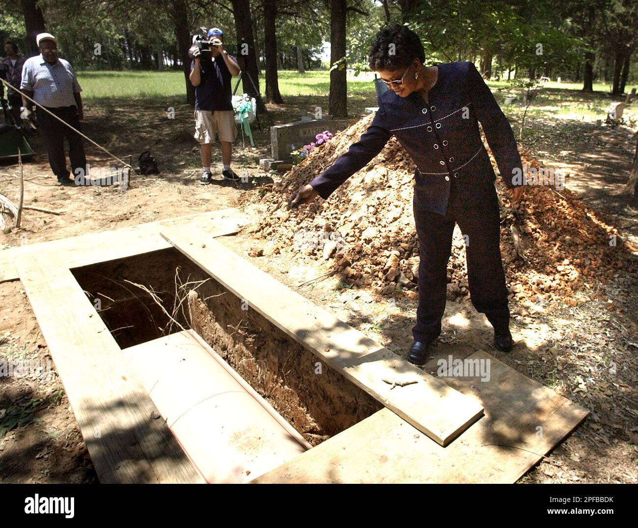 Rosalynn Williams of Bryan, Texas, throws dirt on Mojo's casket after