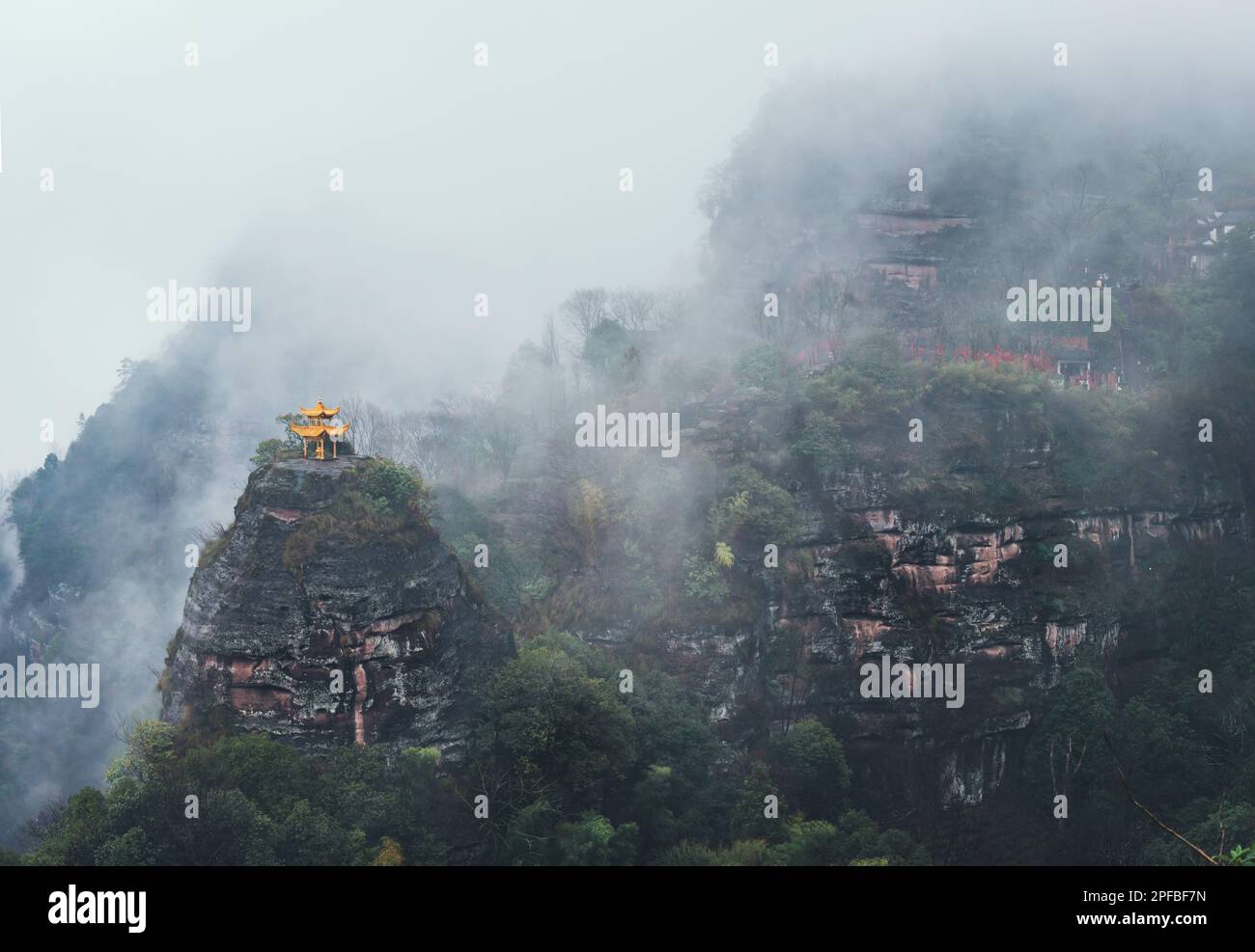 A Chinese Pavilion on the  top of hill in the mist Stock Photo