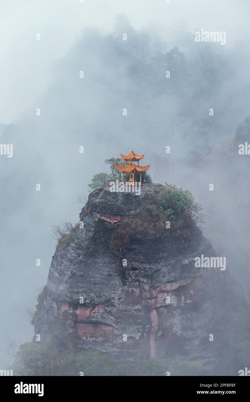 A Chinese Pavilion on the  top of hill in the mist Stock Photo