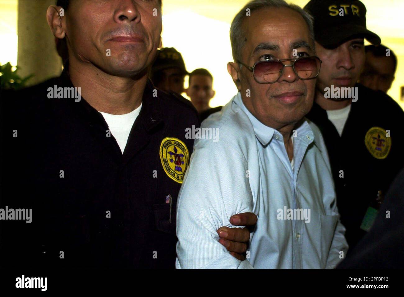 Judicial police officers escort Mario Galdamez to the court room to be  tried on fraud charges in San Salvador, El Salvador, Tuesday, June 5, 2001.  Roberto Mathies Hill and Mario Galdamez are