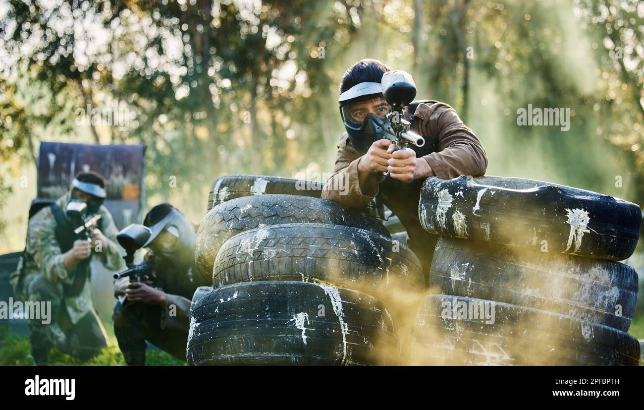Team, paintball and tires for cover bunker or protection while firing